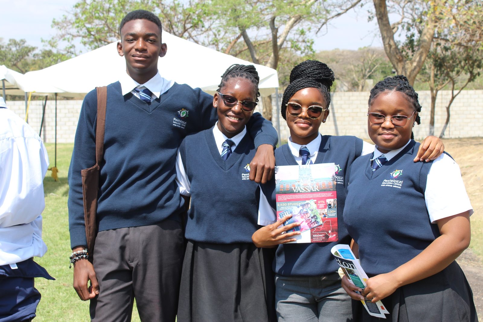 HALI-affiliated students at a college fair with a university brochure